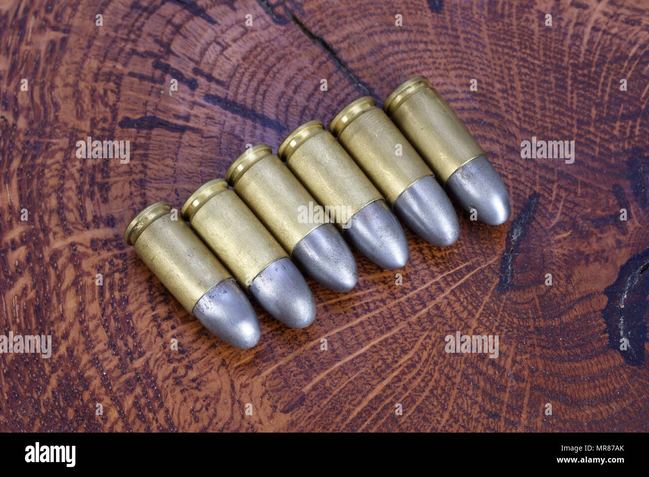 Il calibro 9mm cartuccia su sfondo di legno Foto Stock