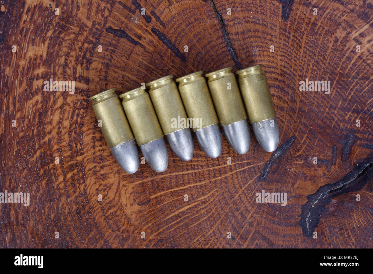 Il calibro 9mm cartuccia su sfondo di legno Foto Stock