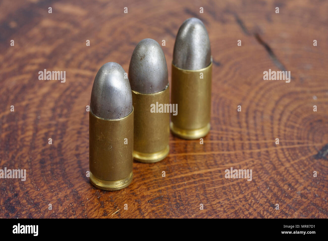 Il calibro 9mm cartuccia su sfondo di legno Foto Stock