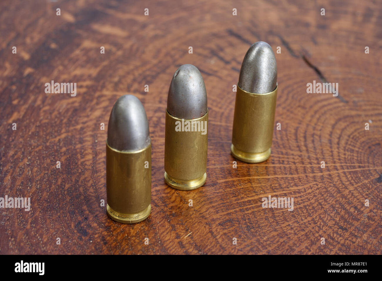 Il calibro 9mm cartuccia su sfondo di legno Foto Stock