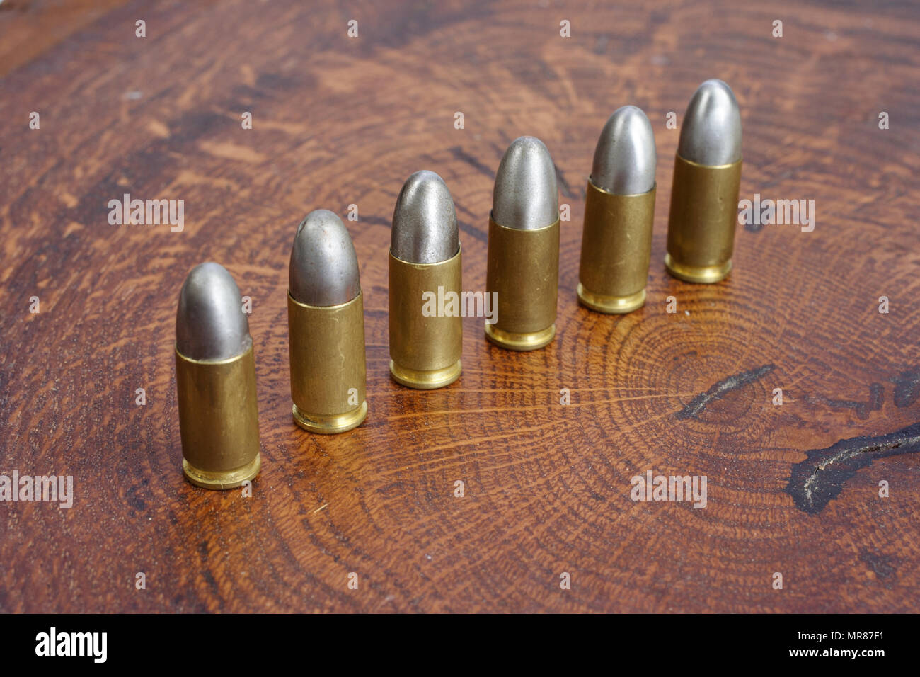 Il calibro 9mm cartuccia su sfondo di legno Foto Stock