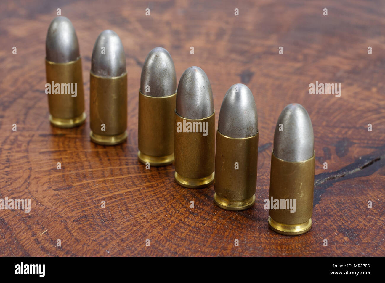 Il calibro 9mm cartuccia su sfondo di legno Foto Stock