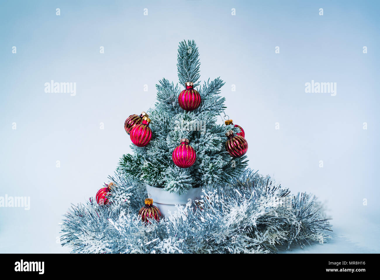 Di piccole dimensioni e decorata anno nuovo albero in bianco e lo sfondo blu Foto Stock