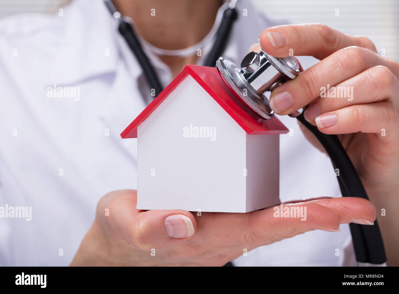 Close-up di un controllo medico il modello semplice casa con uno stetoscopio Foto Stock