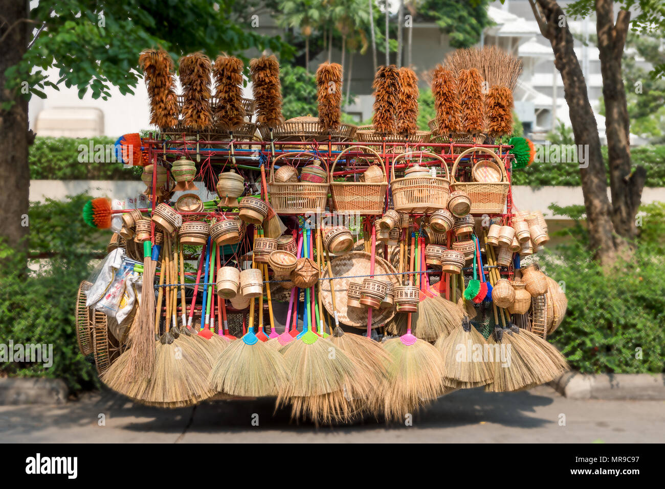 Selezione di articoli di pulizia - brroms, ceste, spazzole - impilate su di un carrello pronto per essere offerto in vendita a Bangkok, in Thailandia Foto Stock