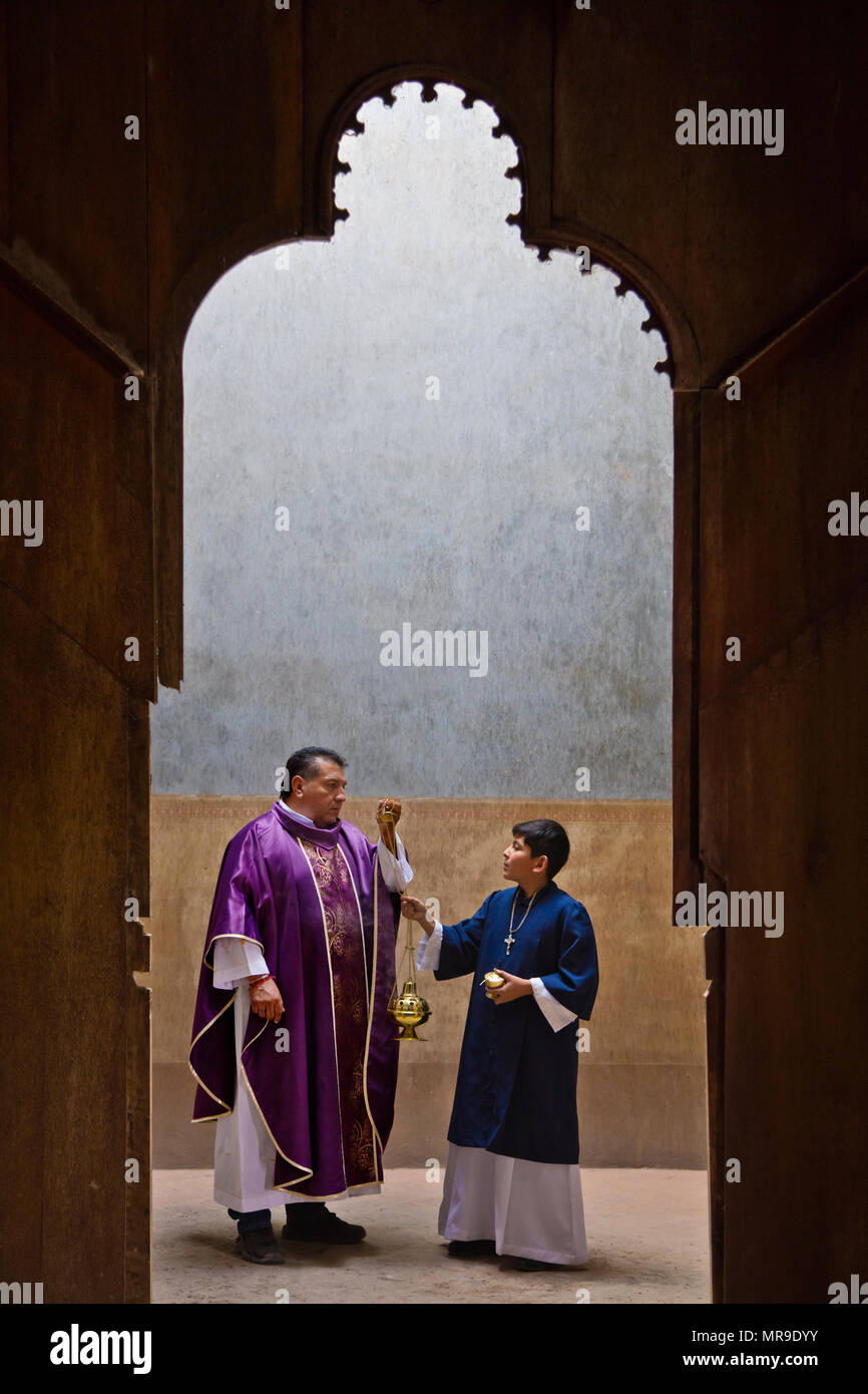 Un prete cattolico parla con il suo alcolyte in preparazione di una processione di Pasqua - SAN FELIPE, Messico Foto Stock