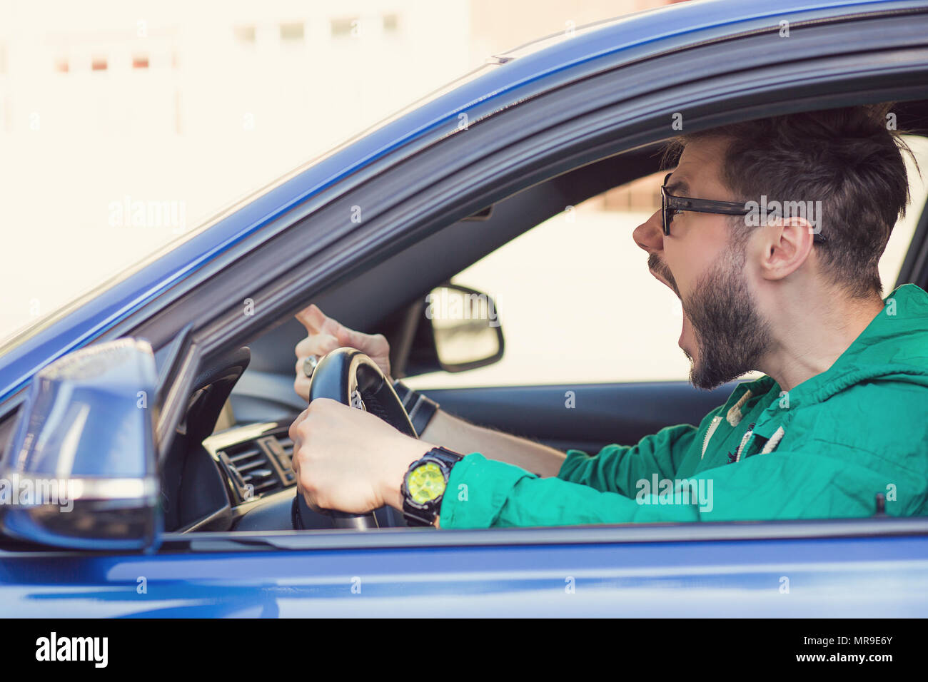 Profilo laterale arrabbiato hipster uomo driver. Negative le emozioni umane espressione faccia Foto Stock