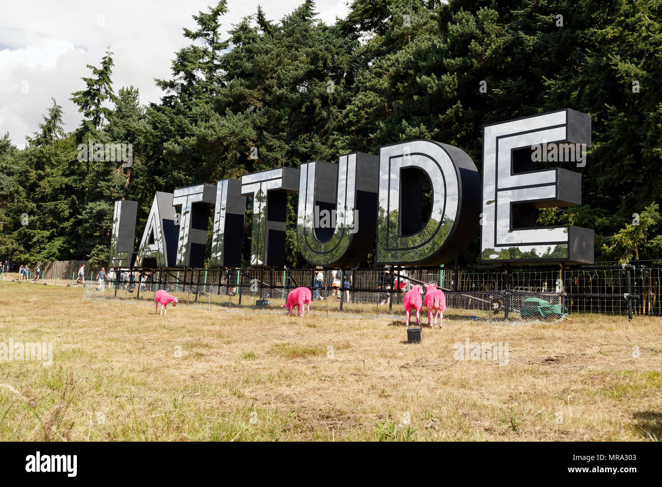 Il notebook Latitude Festival segno a Henham Park, Suffolk, Regno Unito durante il 2017 evento. Attorno al logo sono il festival iconici tinte di rosa pecore. Foto Stock