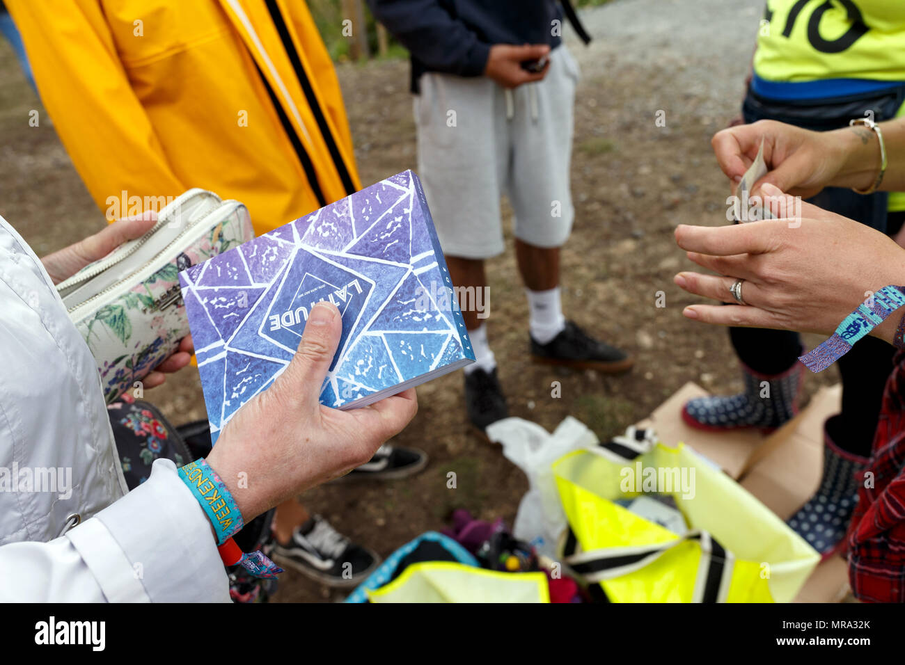 Un festival goer acquistando un ufficiale del festival programma al Festival Latitude 2017. Foto Stock