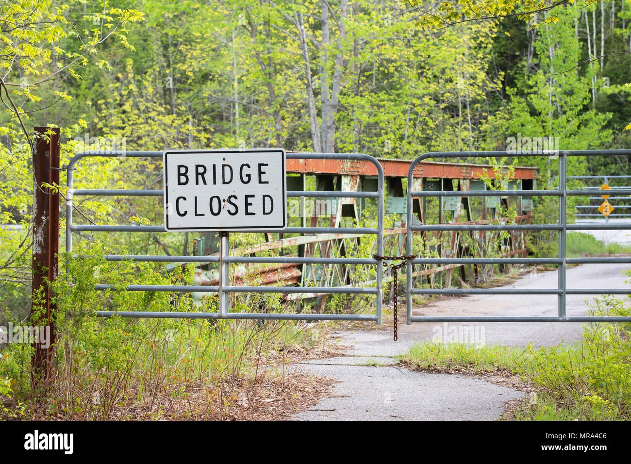 Un cancello con un ponte chiuso segno su una inutilizzata trascurato ponte sopra il fiume Sacandaga nell'Adirondack, NY deserto Foto Stock