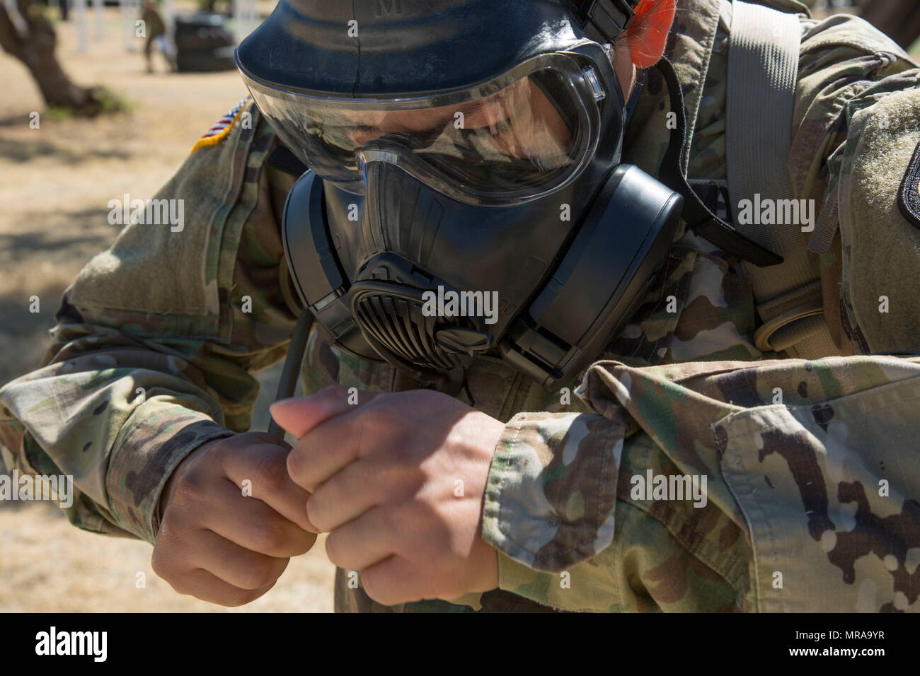 Stati Uniti Pfc dell'esercito. Jessica Estrada, assegnato alla sede centrale e sede Azienda (HHC) rete Enterprise Technology Command (NETCOM), si prepara a bere dal suo camelback mentre indossa una maschera a gas durante il 2017 NETCOM guerriero migliore concorrenza a Fort Huachuca, Az., 18 maggio 2017. La concorrenza è riempito con vari eventi e attività progettate per valutare le loro conoscenze, forza e disciplina per guadagnare il titolo di 2017 NETCOM miglior guerriero. (U.S. Esercito foto di Spc. Tianna S. Wilson) Foto Stock