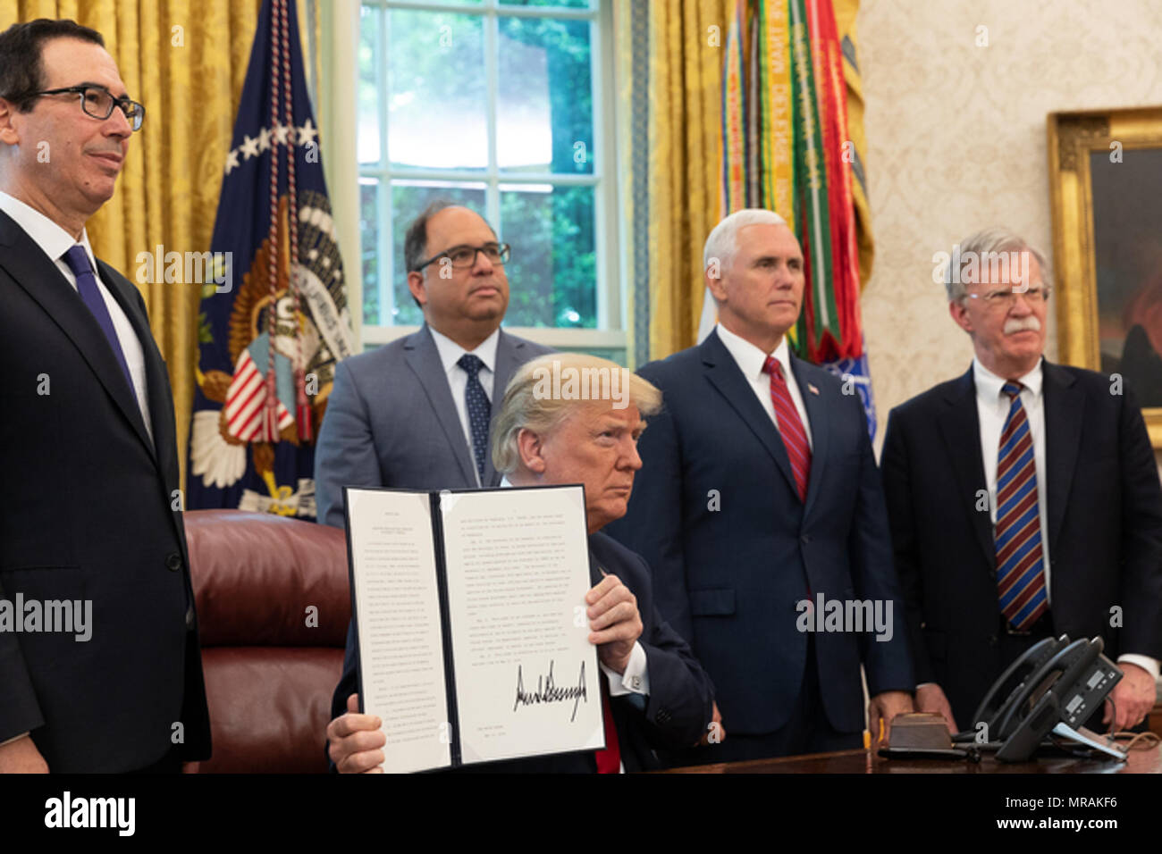 WASHINGTON, DC - settimana di maggio 21: Presidente Trump, uniti dal Vice Presidente Mike Pence, destra, U.S. Il segretario al Tesoro Steven Mnuchin,sinistra e consigliere per la Sicurezza Nazionale John Bolton, destra, nell'Ufficio Ovale della Casa Bianca, visualizza la sua firma un ordine esecutivo di prendere in considerazione ulteriori misure per affrontare la situazione in Venezuela, lunedì, 21 maggio 2018, a Washington D.C. Persone: presidente Donald Trump Foto Stock