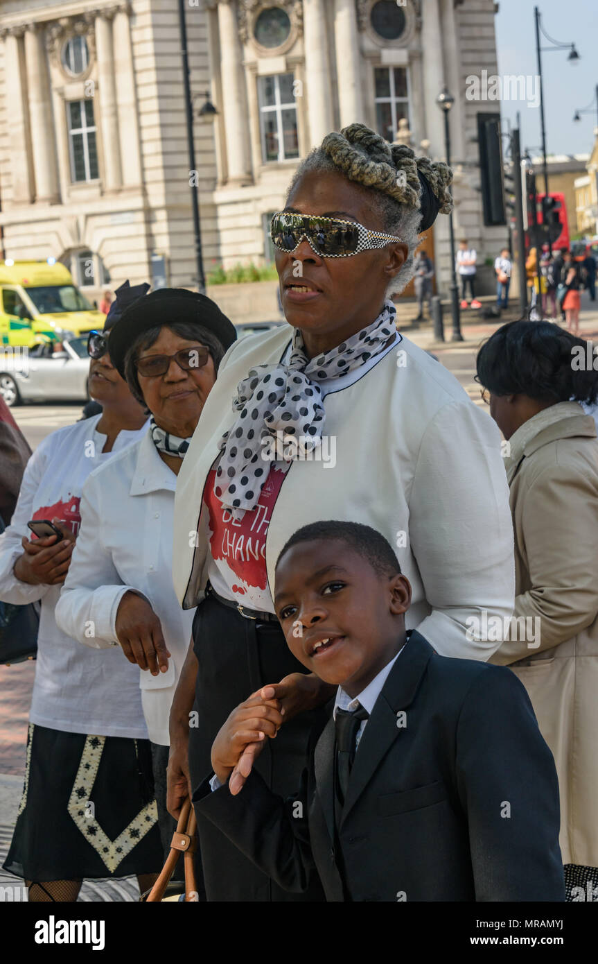 Londra, Regno Unito. 26 Maggio, 2018. Persone di ascoltare come un coro canta alla Brixton La Chiesa Avventista del Settimo Giorno 'Essere il cambiamento' evento in Piazza Windrush, Brixton contro la pistola e il coltello della criminalità. Essi avevano marciato la breve distanza della piazza della chiesa e sono state appena iniziando un programma di canto gospel, presentazioni e la preghiera per la comunità e per coloro che sono colpiti da questi crimini. Londra il tasso di omicidi è aumentata di oltre un terzo negli ultimi tre anni e lo scorso anno ha visto un aumento del 22% registrato nella criminalità coltello e 11% nella pistola criminalità. Credito: Peter Marshall / Alamy Live News Foto Stock