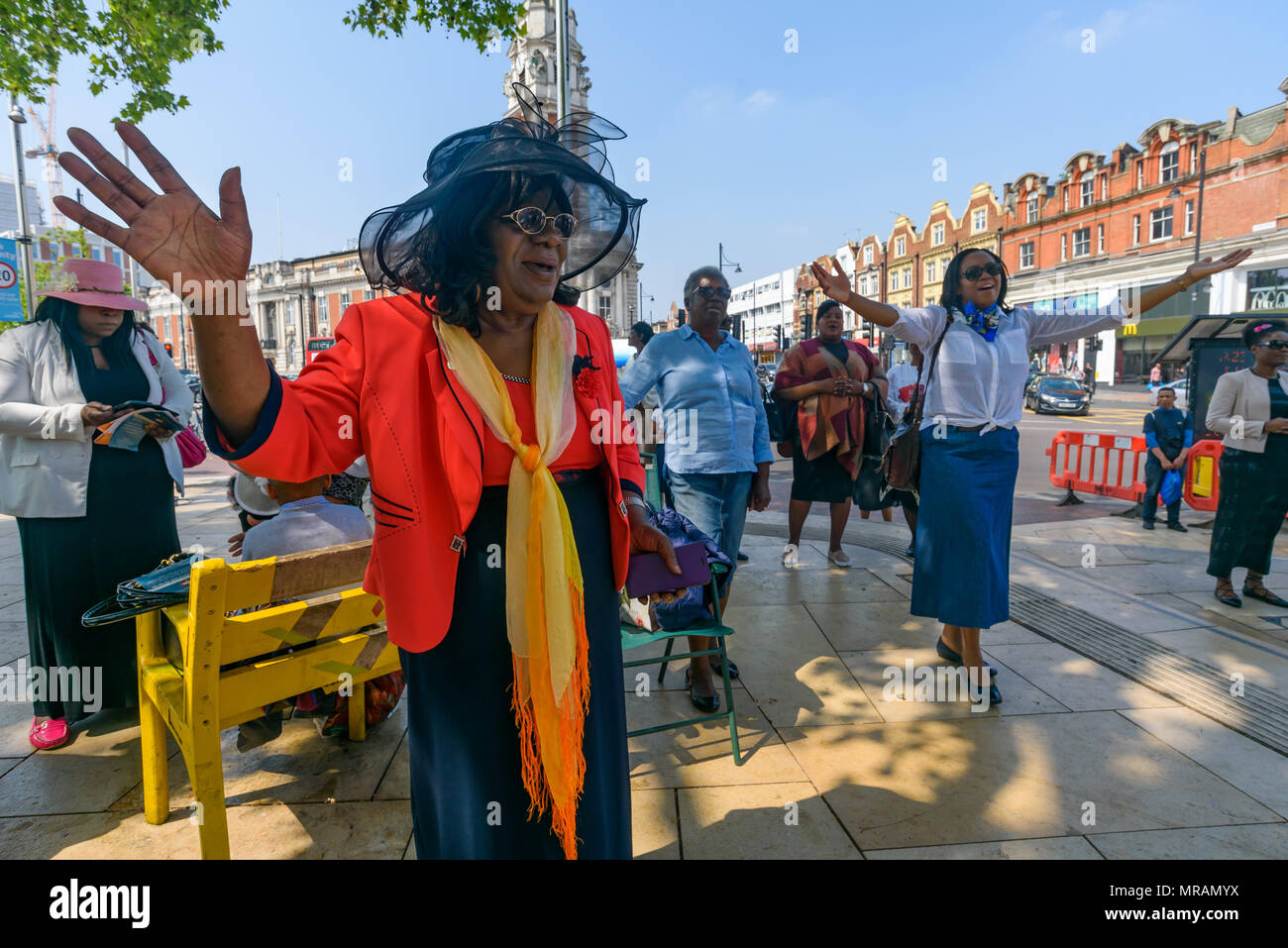 Londra, Regno Unito. 26 maggio 2018. Persone riase le loro mani per la musica di un coro gospel alla Brixton La Chiesa Avventista del Settimo Giorno 'Essere il cambiamento' evento in Piazza Windrush, Brixton contro la pistola e il coltello della criminalità. Essi avevano marciato la breve distanza della piazza della chiesa e sono state appena iniziando un programma di canto gospel, presentazioni e la preghiera per la comunità e per coloro che sono colpiti da questi crimini. Londra il tasso di omicidi è aumentata di oltre un terzo negli ultimi tre anni e lo scorso anno ha visto un aumento del 22% registrato nella criminalità coltello e 11% nella pistola criminalità. Foto Stock