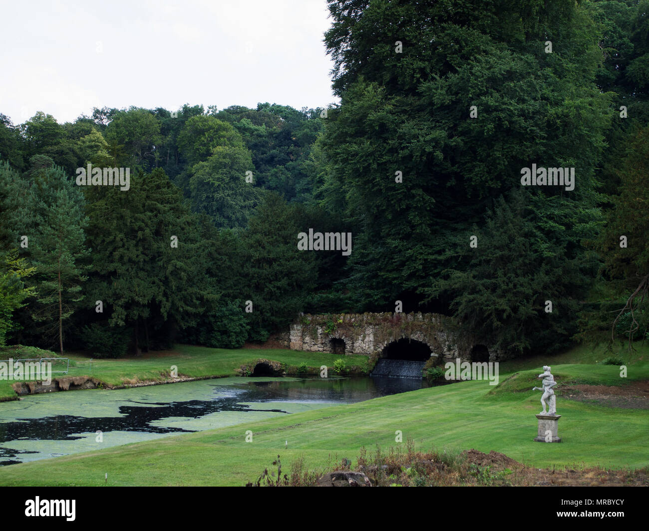 Il ponte di pietra di fiume Skell nel giardino di Fountains Abbey, Ripon, Regno Unito Foto Stock