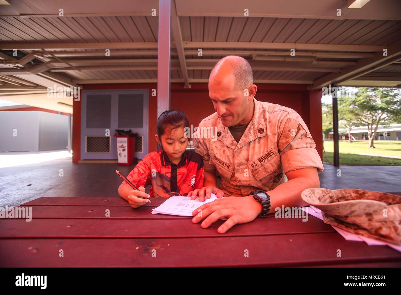 DARWIN Australia - STATI UNITI Il personale marino Sgt. Il Bret Daneker, plotone sergente, azienda I, 3° Battaglione, 4° Reggimento Marini, 1° Divisione Marine, Marine forza rotazionale di Darwin, tutor un bambino con la sua grammatica lavoro scuola durante un evento di volontariato, 31 maggio 2017. Lo stesso gruppo di Marines continuerà la visita e guida gli studenti durante tutto il loro tempo in Darwin. I marines si sono impegnati a servire la comunità locale e continuerà ad avere un impatto quando disponibile. (U.S. Marine Corps foto di Sgt. Emmanuel Ramos) Foto Stock