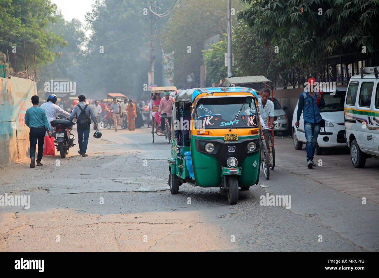 Delhi, India - 20 Novembre 2015:-Tuk Tuk colorati veicoli e pedoni in un affollato traffico di Delhi con smog visibile dell'inquinamento atmosferico Foto Stock