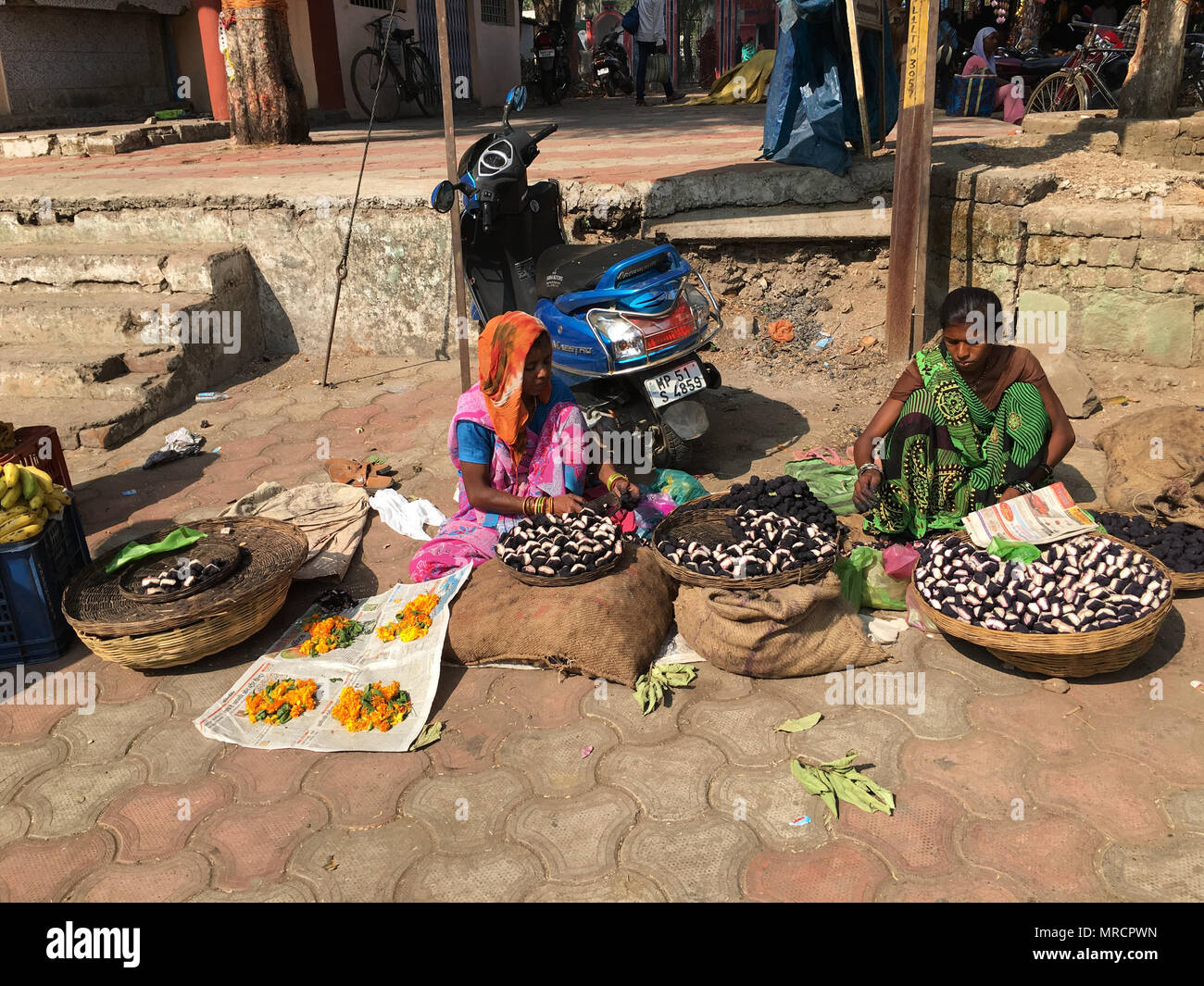Mandla, Madhya Pradesh, India - 25 Novembre 2015: le donne indiane con colorati indumenti tradizionali di vendere i loro prodotti a un informale street market Foto Stock
