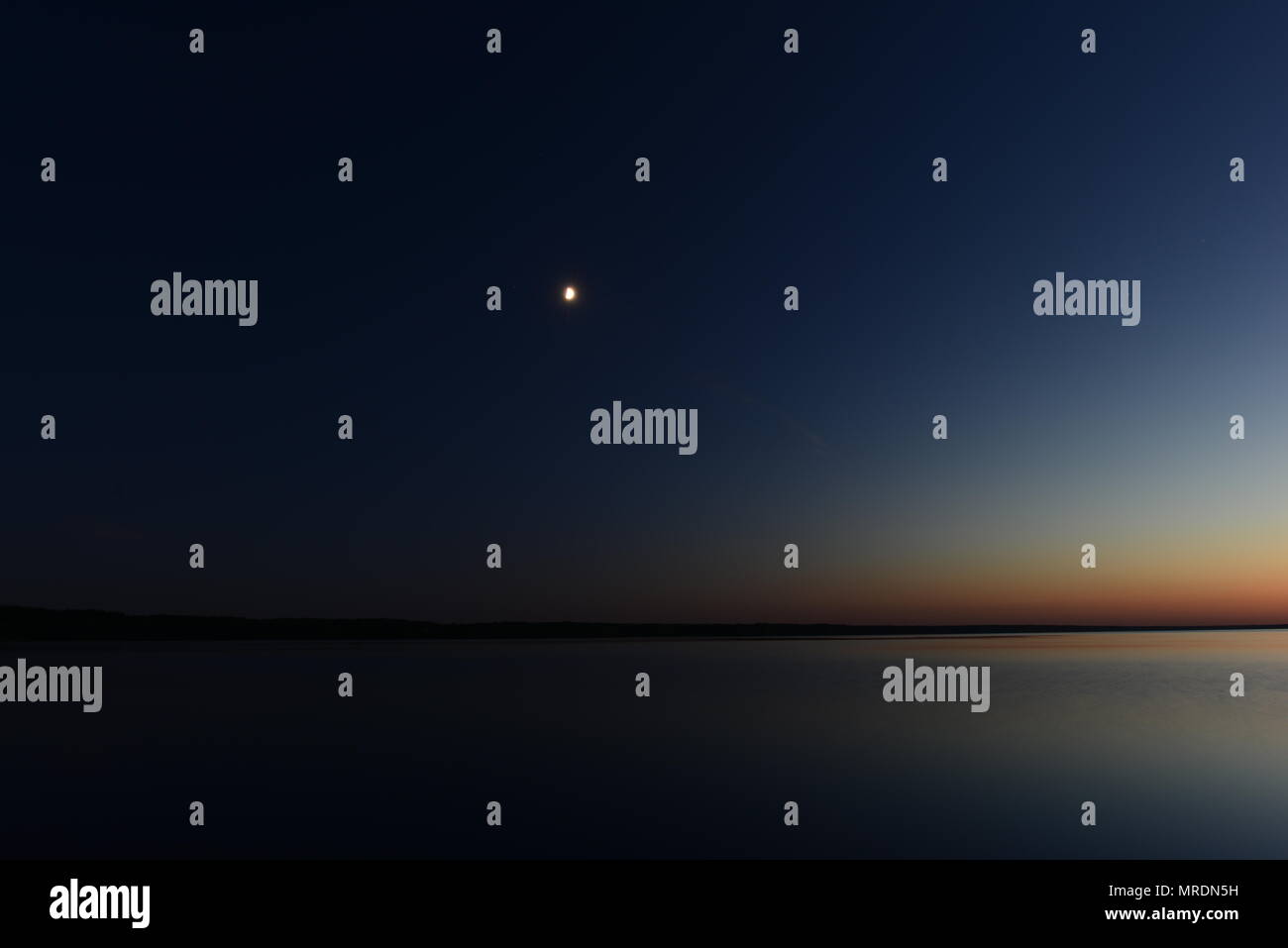 Le tenebre e la luce dal chiaro di luna nella notte oscura il cielo sopra il lago Foto Stock