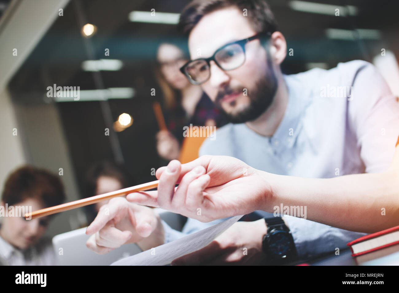 Uomo Barbuto parlando con il collega circa il nuovo progetto di avvio. Coworking brainstorming team in ufficio moderno Foto Stock