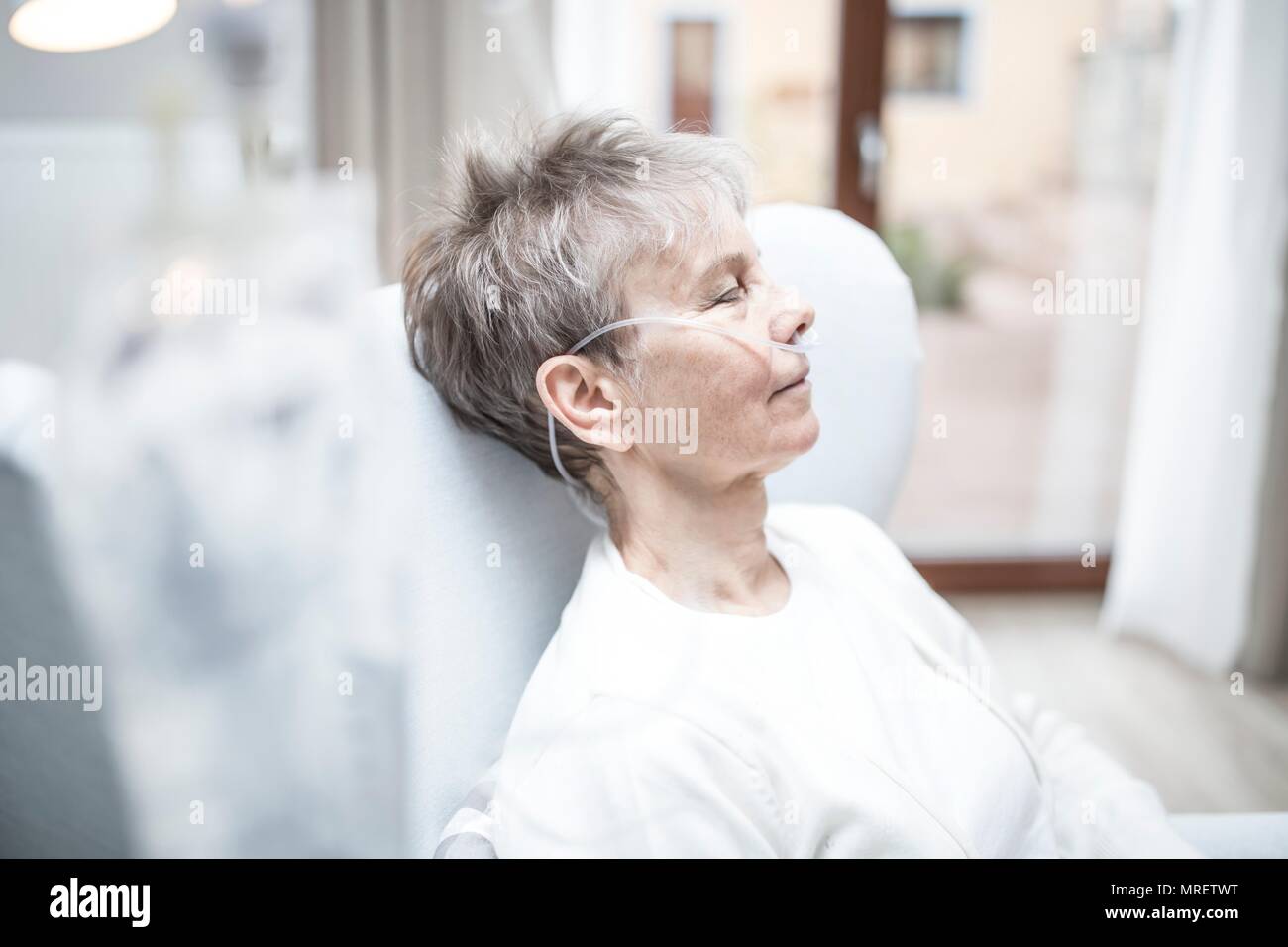 Senior donna con cannula nasale. Foto Stock