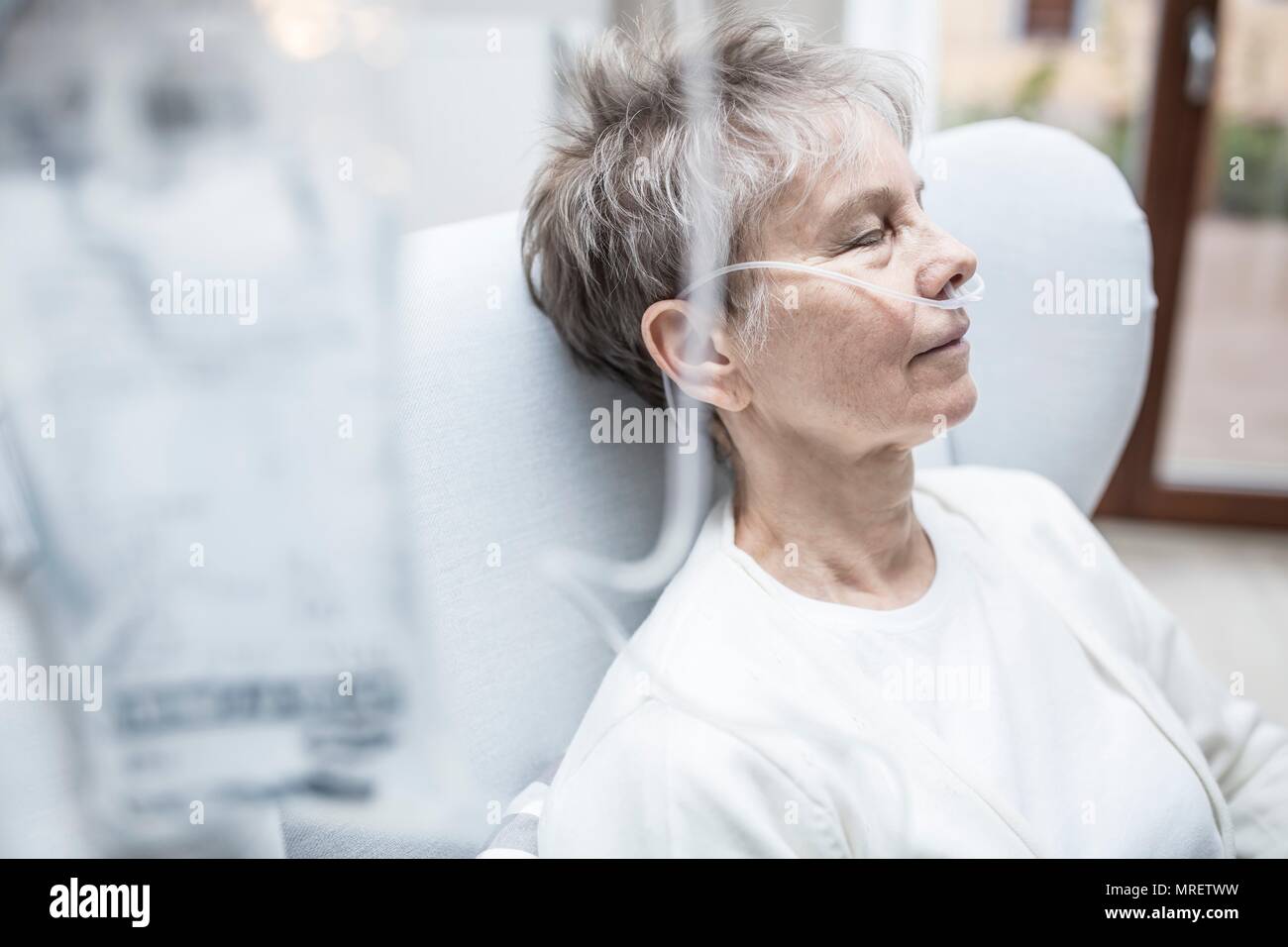 Senior donna con cannula nasale e la sacca per infusione. Foto Stock