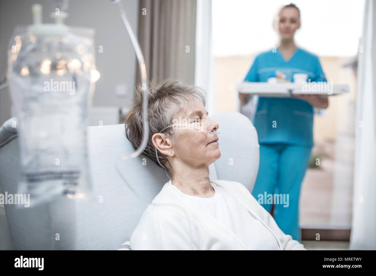 Senior donna con cannula nasale e la sacca per infusione. Foto Stock