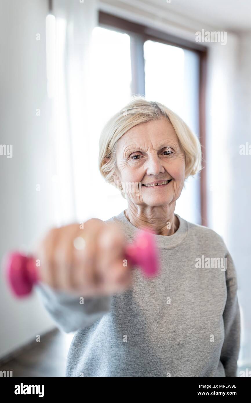 Senior donna tenendo la mano di peso. Foto Stock
