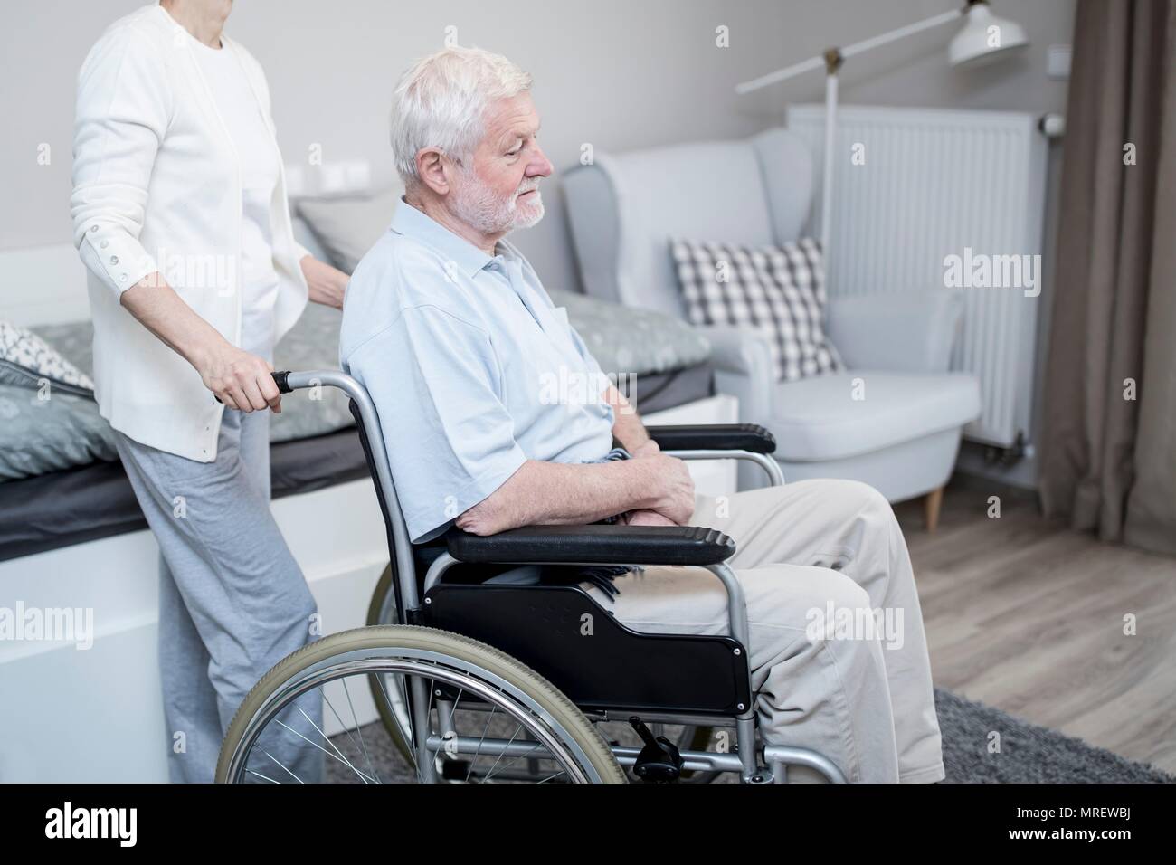 Senior uomo in carrozzella con la donna nella casa di cura. Foto Stock