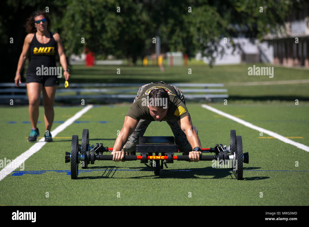 Cpl. Troy Savageau esegue un 50-cantiere bassa strisciare su "La Rana" come Nicole Freres, HITT Livello Istruttore di due documenti del suo tempo, durante il 2017 atleta tattico concorrenza eliminatorie al Marine Corps base Camp Lejeune, 9 giugno 2017. "La Rana" è una macchina di allenamento che utilizza bande di resistenti per ottenere un corpo pieno esercizio. Savageau è una refrigerazione e condizionamento di aria tecnico con il secondo aeromobile marino ala. (U.S. Marine Corps foto di PFC. Nathan Reyes) Foto Stock