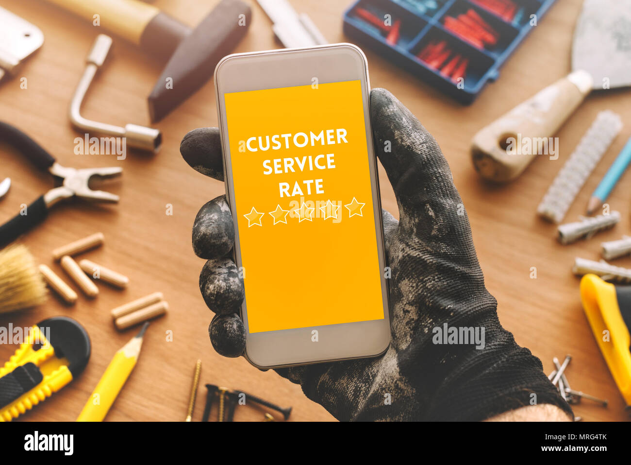 Rating Servizio clienti per tuttofare di riparazione e di attività di manutenzione. Repairman tramite telefono cellulare, vista dall'alto Foto Stock