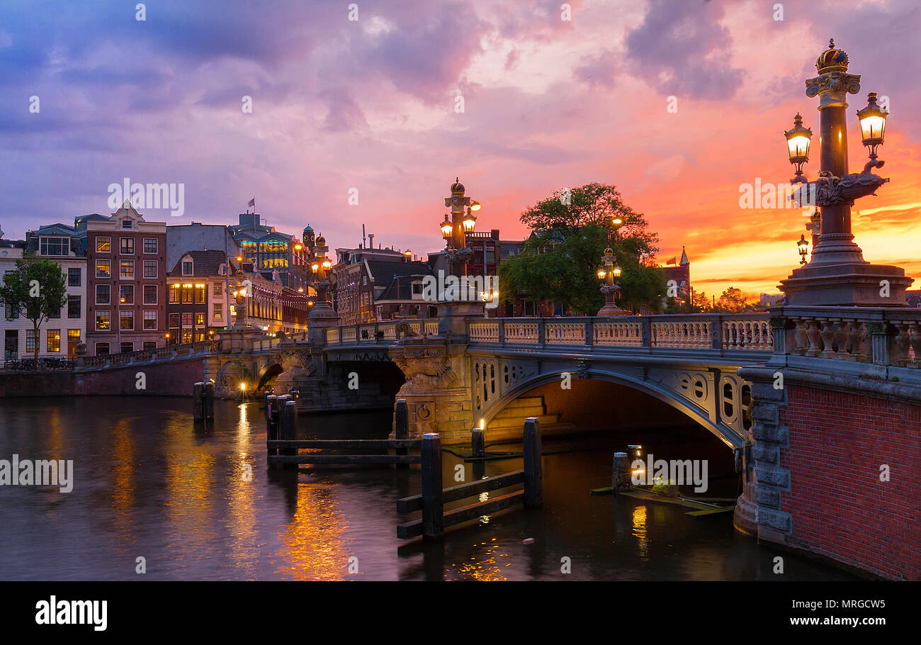 Blu Blauwbrug ponte sul fiume Amstel di Amsterdam al tramonto sera primaverile, Olanda. Foto Stock