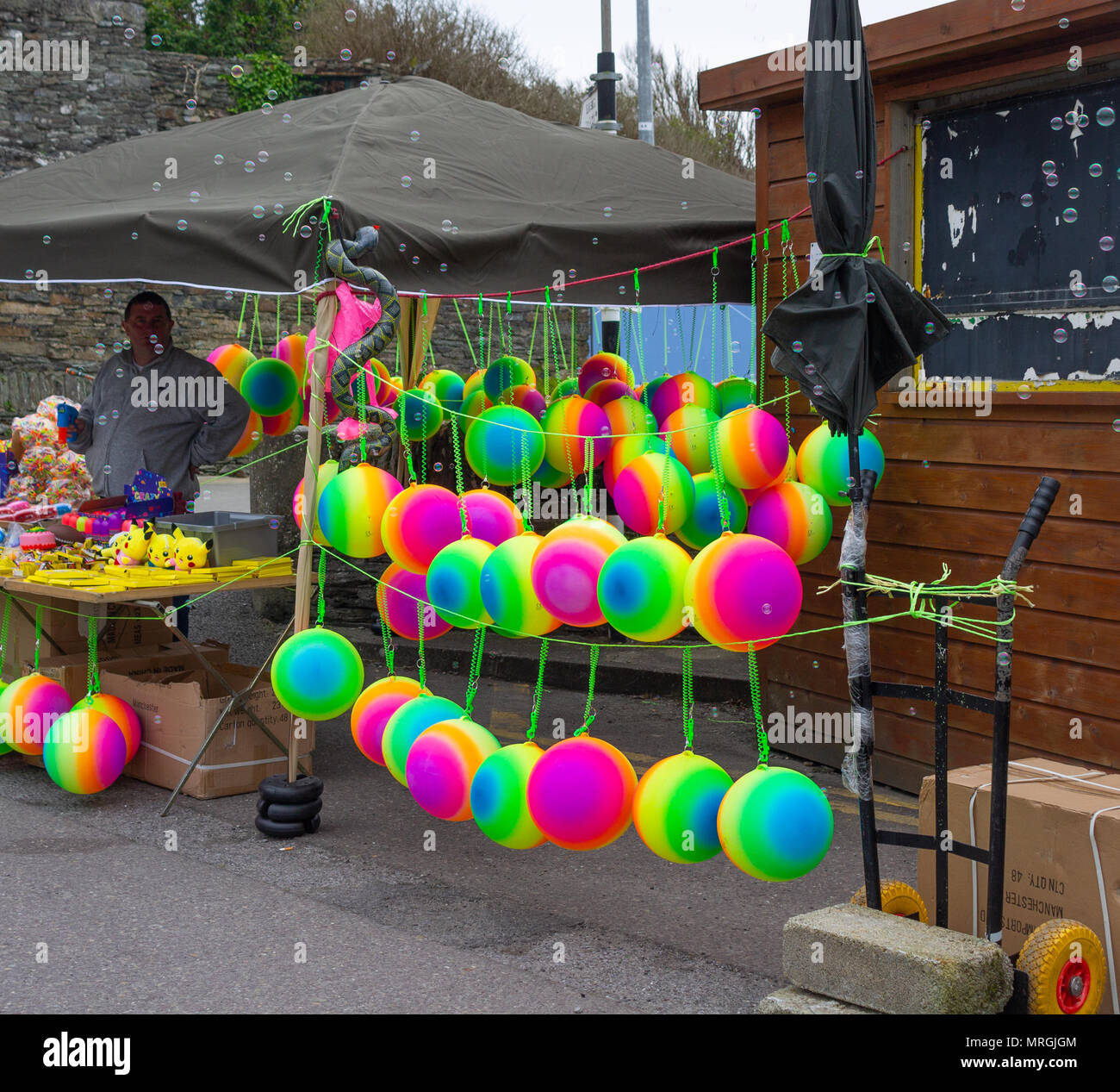 Venditore ambulante vendendo luminose sfere multicolore in un festival Foto Stock