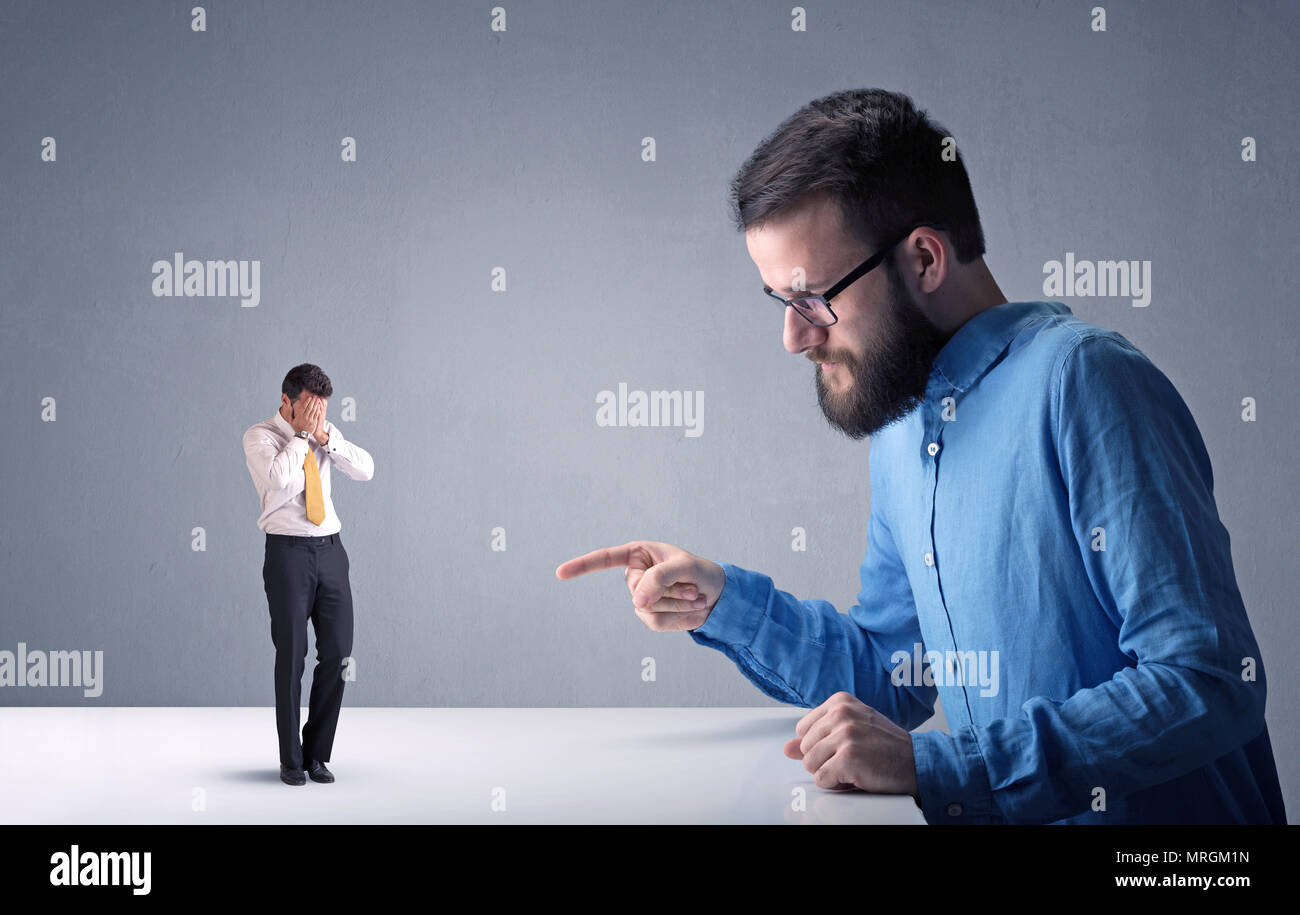 Giovane imprenditore professionale essendo arrabbiato con un altro imprenditore in miniatura Foto Stock