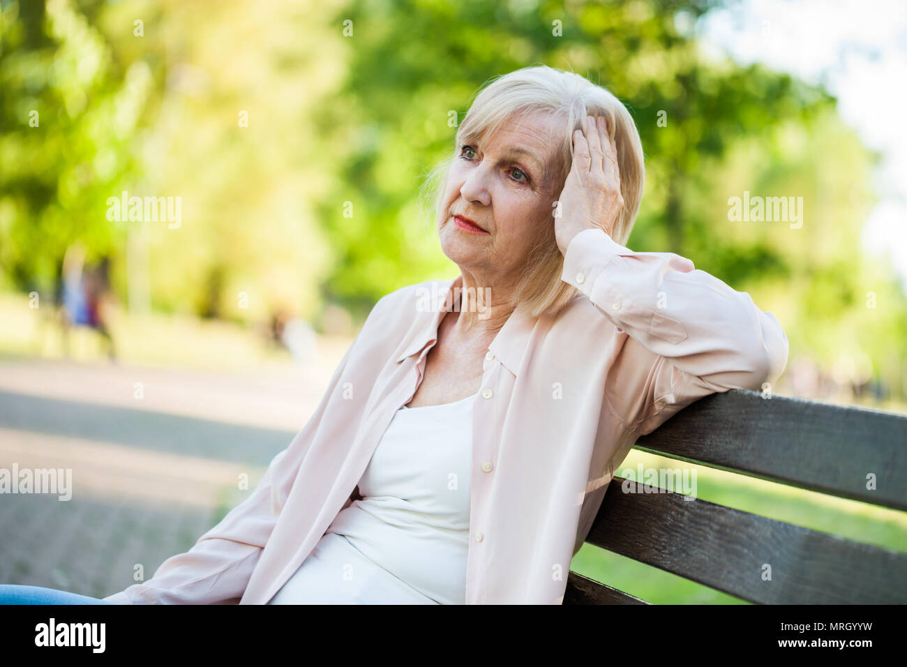 Lonely adulto donna seduta in parco nella disperazione. Foto Stock