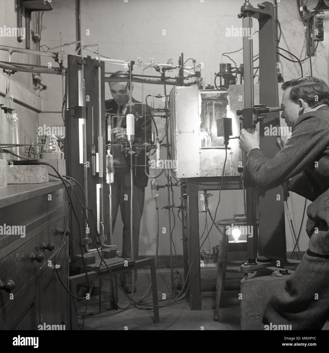 1948, storico, maschio gli scienziati che lavorano con apparecchiatura di ser in un laboratorio della scienza all Università di Leeds, Leeds, Inghilterra, Regno Unito. Dopo la guerra molto di investimento è andato nella scienza e Leeds come membro fondatore del prestigioso gruppo di Russell di università è stato all'avanguardia della ricerca. Foto Stock