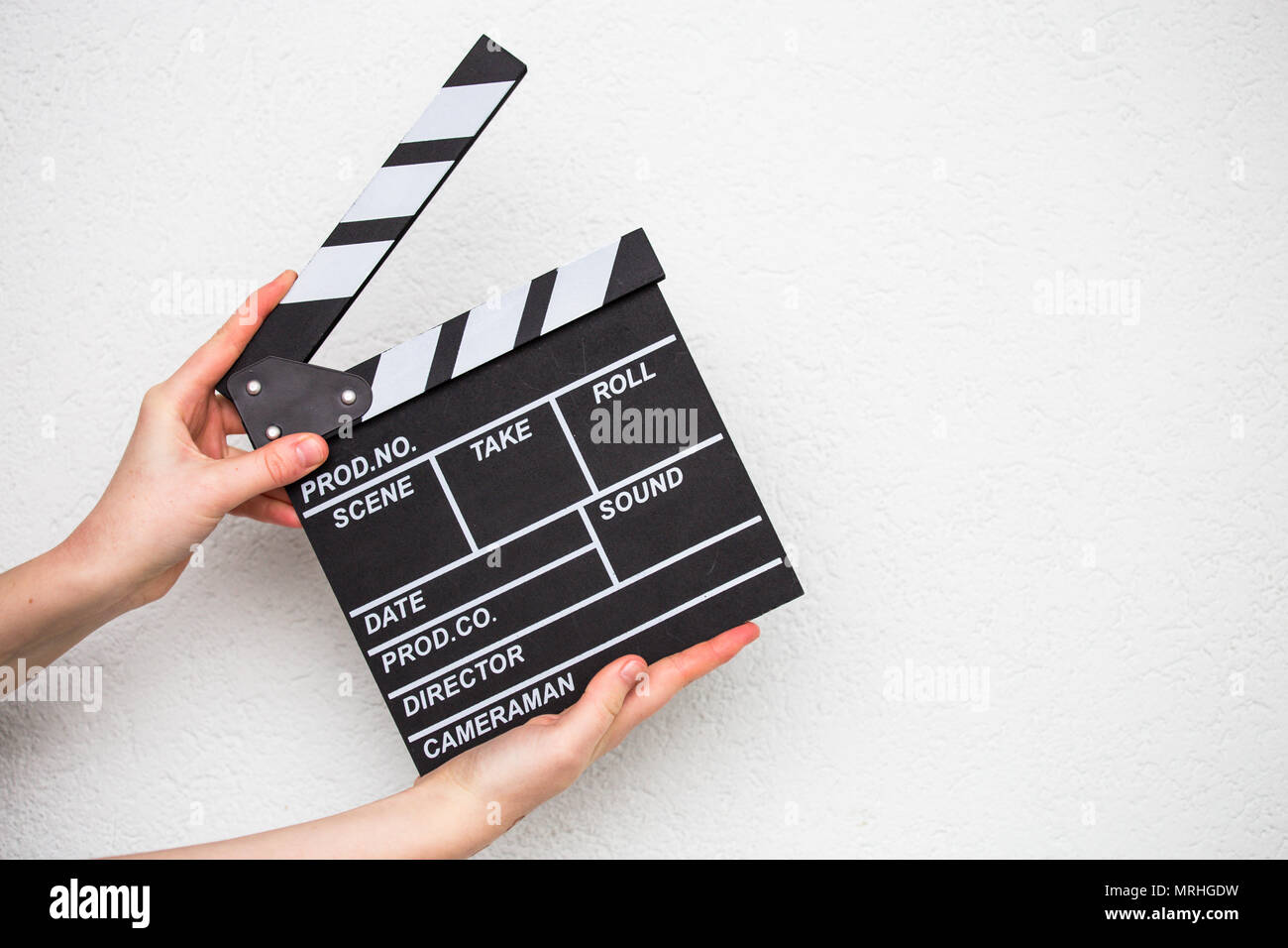 Mani femminili holding movie clapper isolato su bianco Foto Stock