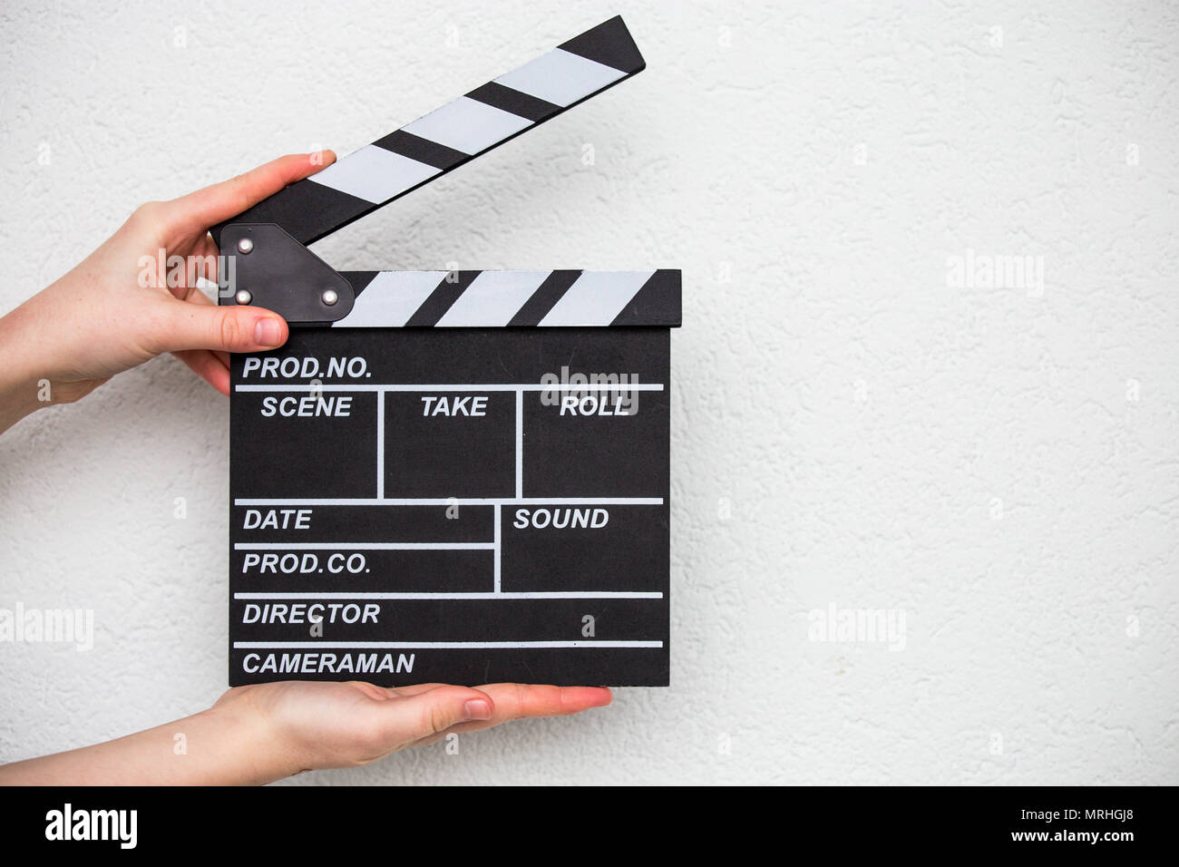 Mani femminili holding movie clapper isolato su bianco Foto Stock