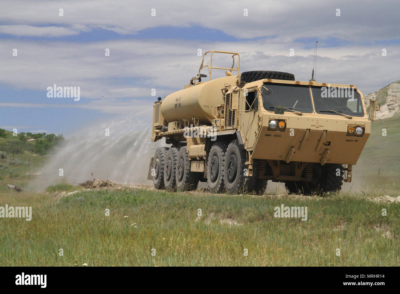 I soldati del sud Dakota esercito nazionale della guardia ingegnere 842nd azienda spray giù per la strada a minimalize mentre la polvere di ricostruire il JB Pass Road in Custer Gallatan National Forest, 15 giugno 2017. SDANG lavorato lungo il lato della armata danese ingegneri e il National Forest Service per completare i progetti stradali come parte della XXXIII Golden Coyote esercitazione. Foto Stock