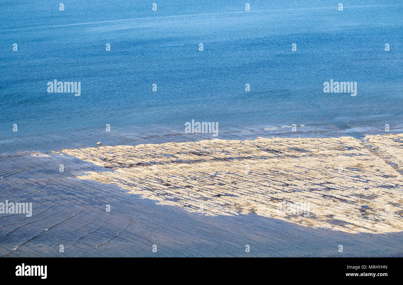 Vista su rocce esposte sulla spiaggia (popolare con i cacciatori di fossili) a bassa marea da scogliere a Saltburn dal mare, North Yorkshire, Inghilterra, Regno Unito Foto Stock