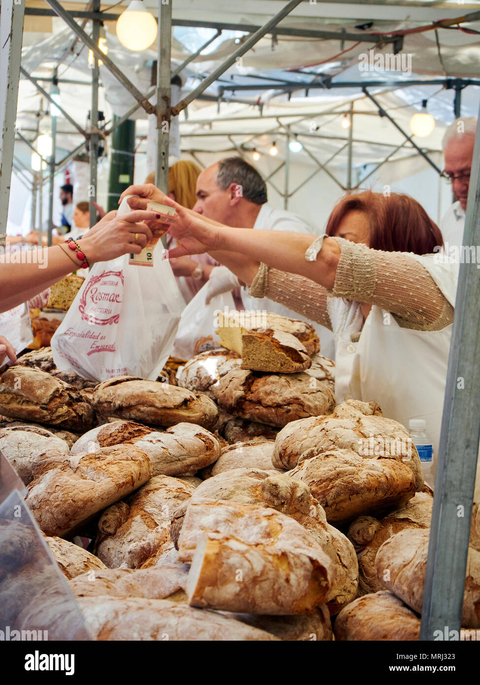 Fornai vendono Hogazas, Spagnola tipica pagnotta di pane in una panetteria in stallo al mercato tradizionale. Foto Stock