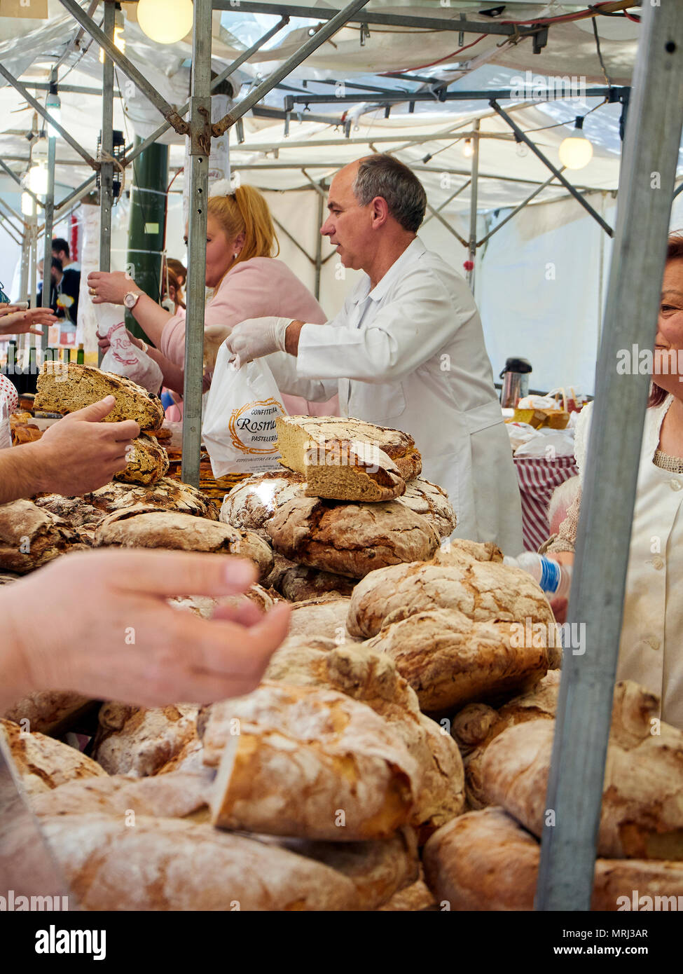 Fornai vendono Hogazas, Spagnola tipica pagnotta di pane in una panetteria in stallo al mercato tradizionale. Foto Stock