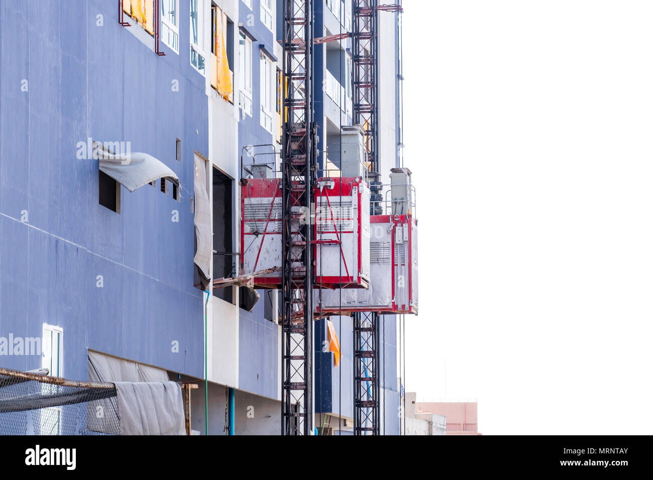 Sollevamento del passeggero e costruzione paranco sollevare utilizzato per sollevare i lavoratori e il materiale presso il sito di costruzione. Foto Stock