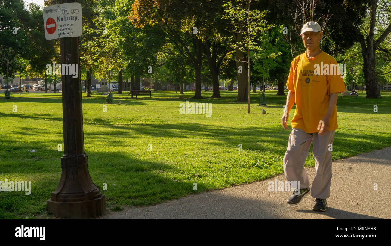 Un uomo di fare una passeggiata nei giardini di Allen in Toronto. Foto Stock