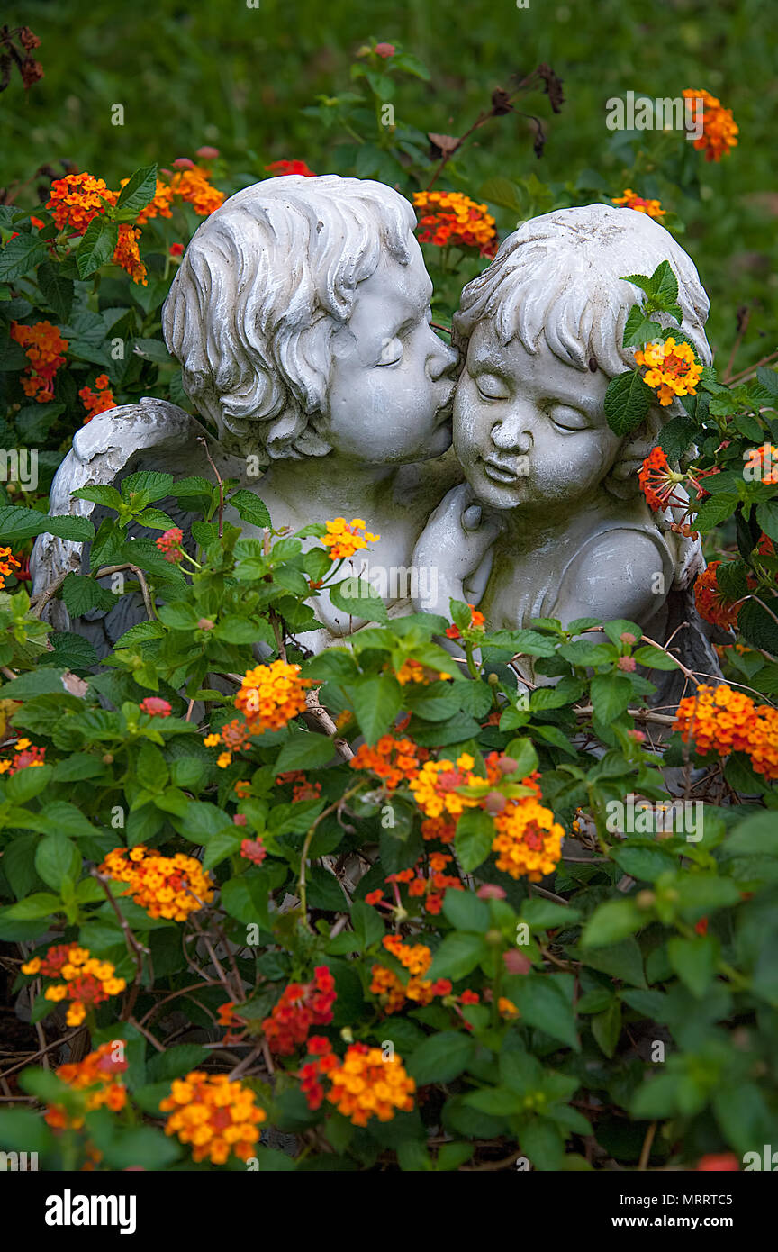 Angeli nell'amore. Sculture di ragazzo e ragazza angeli circondato da fiori  abbracciando e coccole. Il ragazzo angelo è la bacia dalla guancia Foto  stock - Alamy