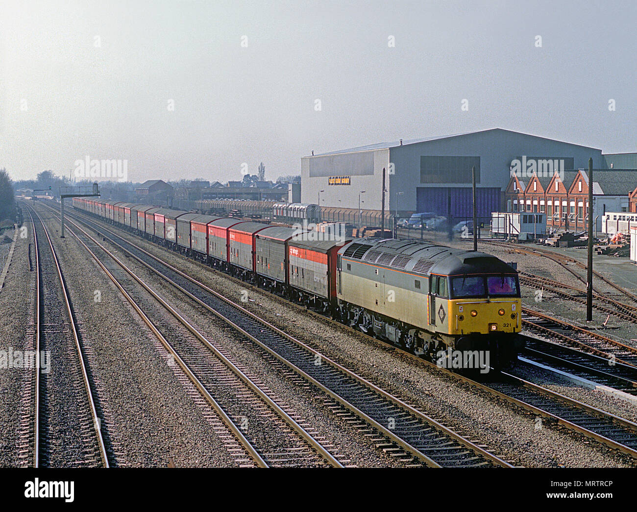 Una classe 47 locomotiva diesel numero 47321 con un lungo treno di quattro ruote di MOD memorizza furgoncini a West Ealing il 13 marzo 1991. Foto Stock Una classe 47 locomotiva diesel numero 47321 con un lungo treno di quattro ruote di MOD memorizza furgoncini a West Ealing il 13 marzo 1991. Foto Stock