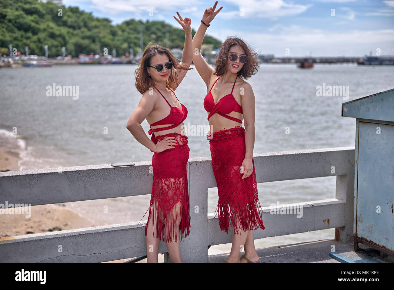 Due donne vestite uguali in abiti di colore rosso. Thailandia del sud-est asiatico Foto Stock