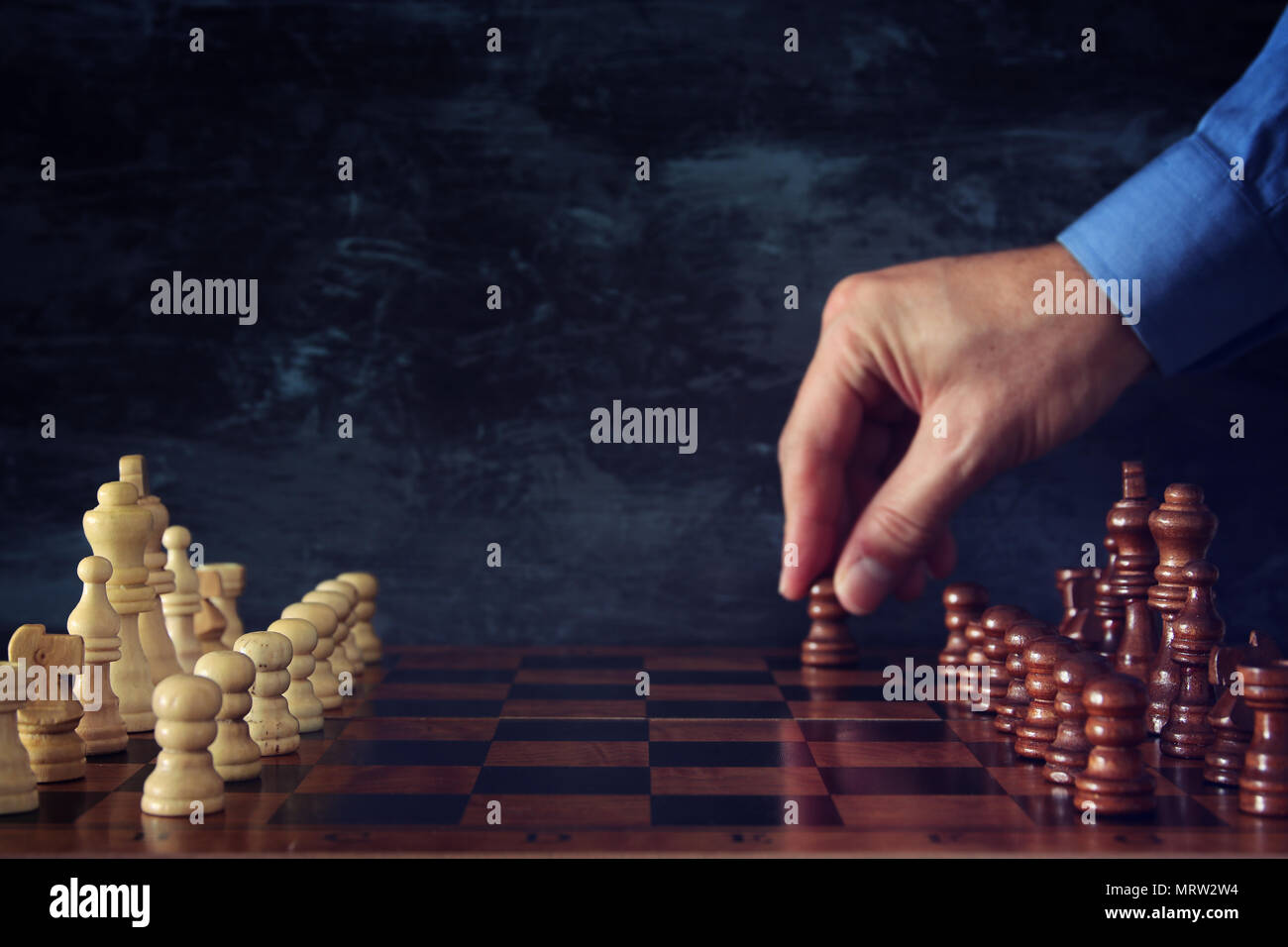 Immagine dell uomo d affari mano scacchi in movimento la figura sulla scacchiera. Business, concorrenza, strategia, la leadership e il concetto di successo Foto Stock