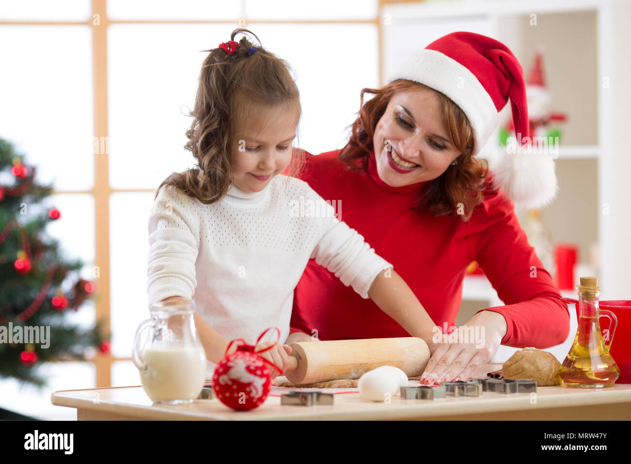 Adorabili poco ragazza del bambino e la madre la cottura biscotti di Natale Foto Stock