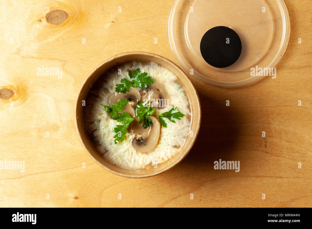 Una zuppa di riso con prezzemolo e gli champignon in scatola di cartone Foto Stock